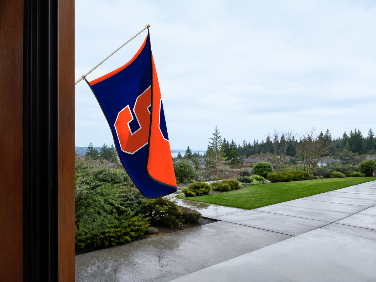 Syracuse Orange Authentic Gameday Flag — approved one-scene environment view — EXO R89 — item_id=ncaa-fbs-syracuse-orange — source_sha256=28d41a8a942ea5858c2607f940130cfa4d5ed3ca48fc12fe2b54a5d710406c7a