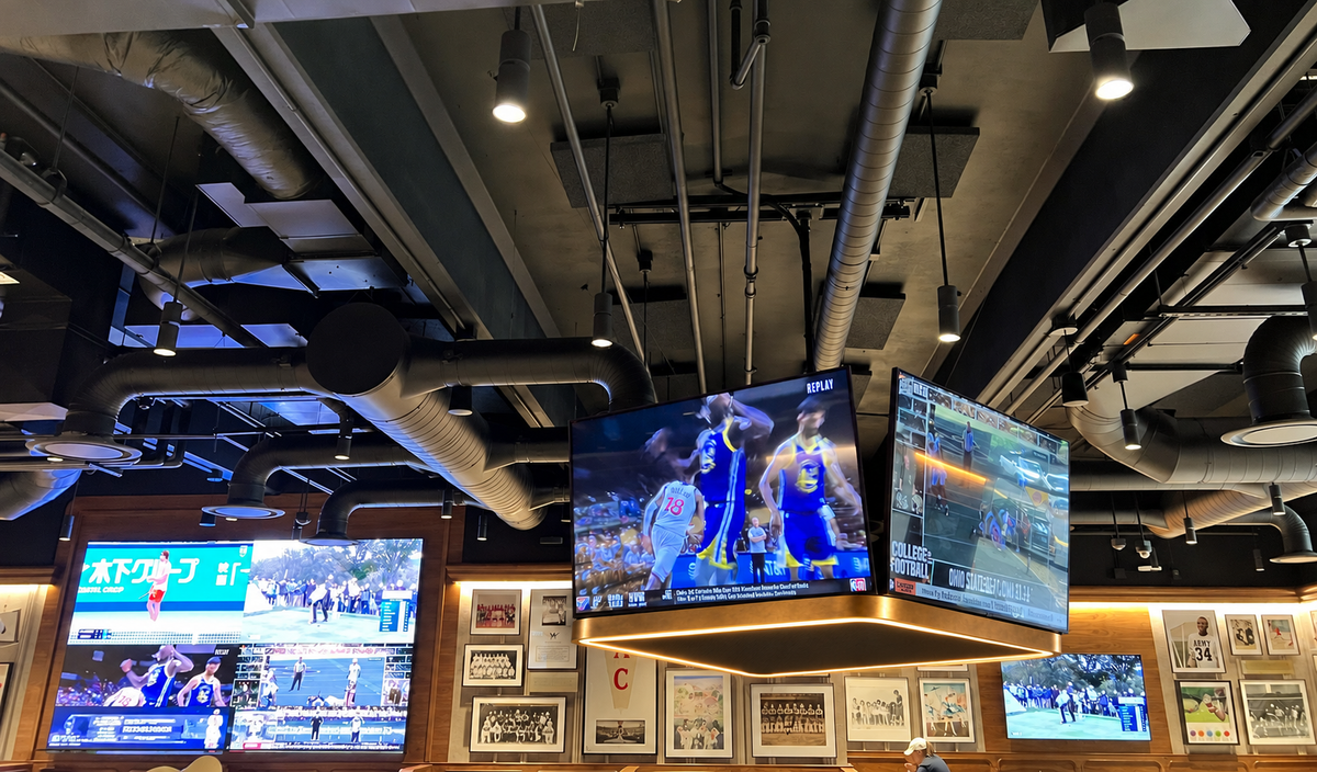 EXO acoustic light canopy installed below independently mounted televisions in a hospitality interior