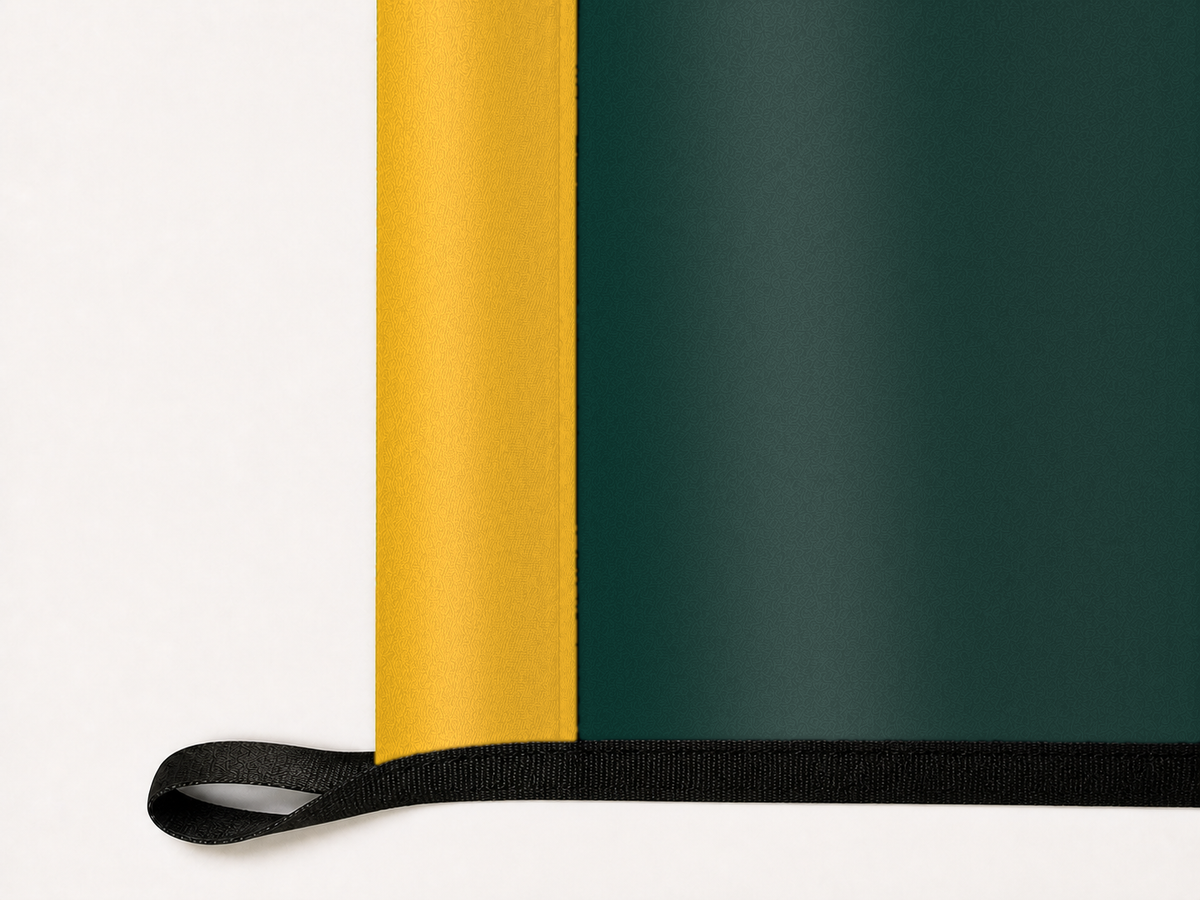 Athletics Authentic Gameday Flag underside and personalization construction view — continuous restrained woven-satin Athletics Accent header, textured Athletics Primary face, lower black loop and perimeter webbing — source_sha256=6cc97bb70495cccc637ac33a6785b3d532497f79cb670a6a2ac8d689bab8e776