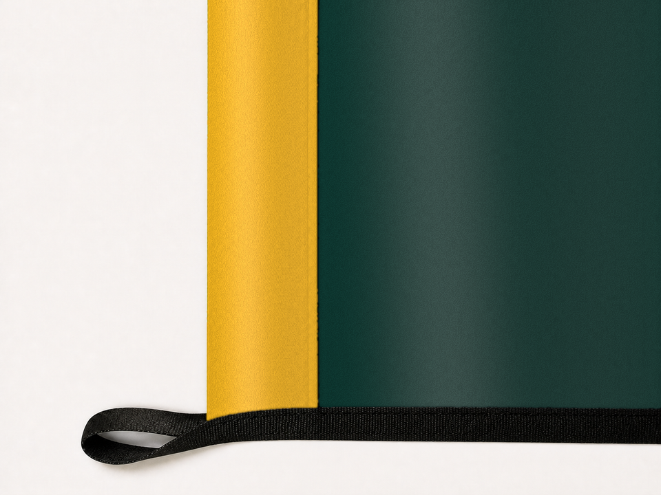 Athletics Authentic Gameday Flag underside and personalization construction view — continuous restrained woven-satin Athletics Accent header, textured Athletics Primary face, lower black loop and perimeter webbing — source_sha256=6cc97bb70495cccc637ac33a6785b3d532497f79cb670a6a2ac8d689bab8e776