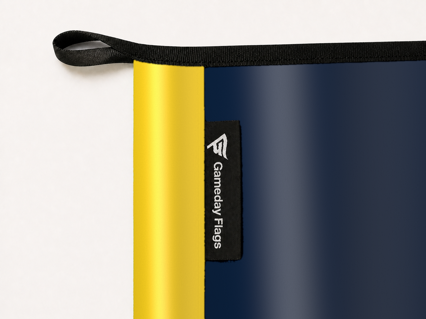 Indiana Pacers Authentic Gameday Flag construction detail — restrained woven-satin Indiana Pacers Accent sewn header, textured Indiana Pacers Primary face, woven Gameday Flags tag, black loop, perimeter webbing, and stitching — source_sha256=a412c1d6d76c9709161bbd47719c02bca79d20527832da405a7e212f36ec53b3