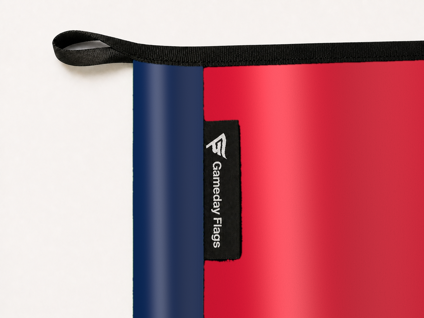 Washington Wizards Authentic Gameday Flag construction detail — restrained woven-satin Washington Wizards Accent sewn header, textured Washington Wizards Primary face, woven Gameday Flags tag, black loop, perimeter webbing, and stitching — source_sha256=628104ec7d7e80e98e6e48c7930517c9bf1c3dae5de22570446dc20167fc1fc4