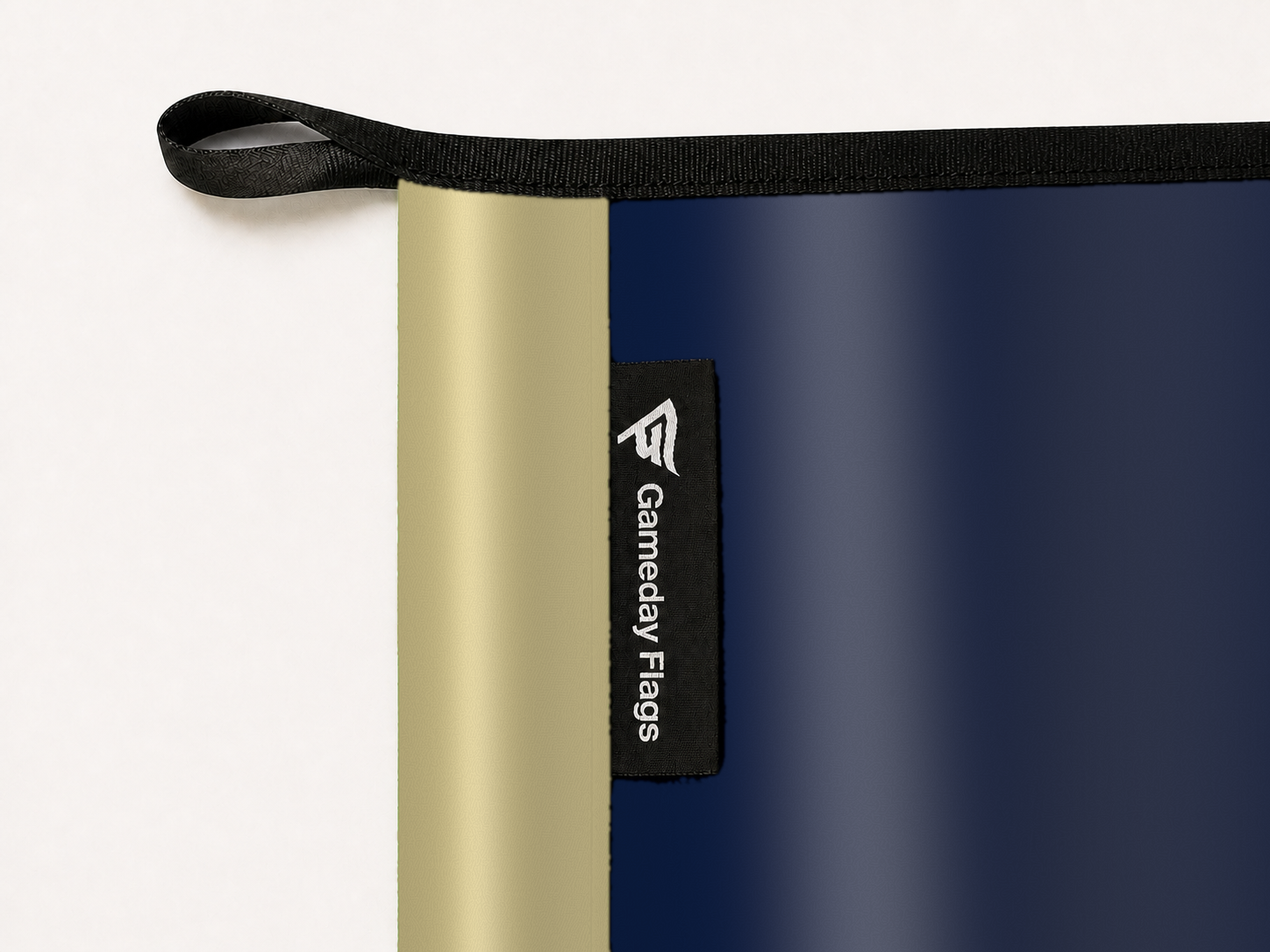 Akron Zips Authentic Gameday Flag construction detail — restrained woven-satin Akron Zips Accent sewn header, textured Akron Zips Primary face, woven Gameday Flags tag, black loop, perimeter webbing, and stitching — source_sha256=a19ba421cd24915037a7d227d379f61a3f890bd43dc616b6744ac5aaf02cdf6c