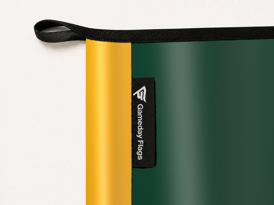 Baylor Bears Authentic Gameday Flag construction detail — restrained woven-satin Baylor Bears Accent sewn header, textured Baylor Bears Primary face, woven Gameday Flags tag, black loop, perimeter webbing, and stitching — source_sha256=eb3f80abcbde029a9fe4daf33a856ddb3d0a6fd10247e74fc07e75d2b6cdb954