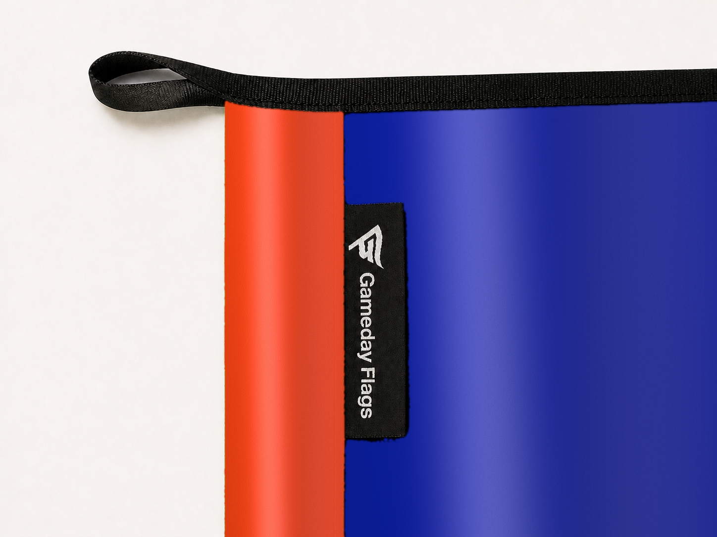 Florida Gators Authentic Gameday Flag construction detail — restrained woven-satin Florida Gators Accent sewn header, textured Florida Gators Primary face, woven Gameday Flags tag, black loop, perimeter webbing, and stitching — source_sha256=bd5a8f283257bbb7a46ec30eea8f94a131207523d174df4031fa8d1efea2c2fa