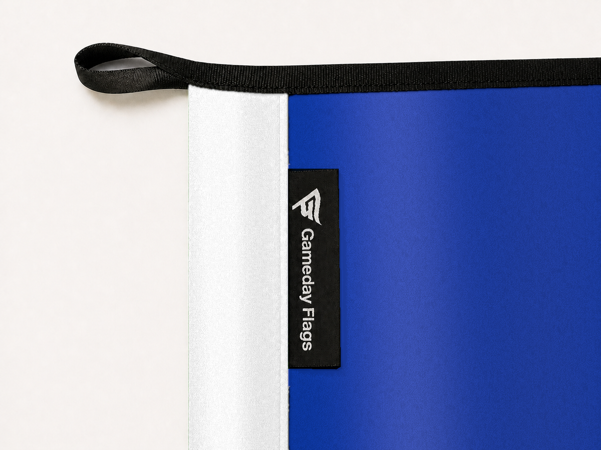 Georgia State Panthers Authentic Gameday Flag construction detail — restrained woven-satin Georgia State Panthers Accent sewn header, textured Georgia State Panthers Primary face, crisp woven Gameday Flags tag and controlled contact shadow, black loop, perimeter webbing, and stitching — source_sha256=9484ebcaf77bc08c52607e2ed7b880640d7f97a50931fc5556267b01f8e8d591