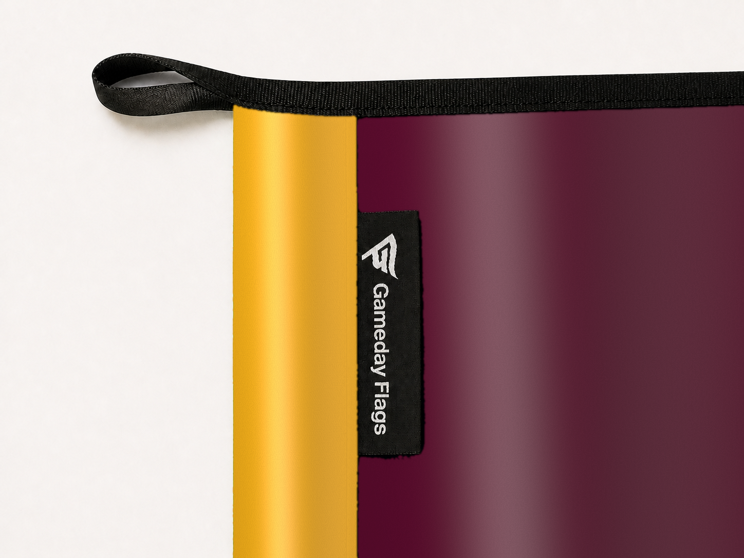 Minnesota Golden Gophers Authentic Gameday Flag construction detail — restrained woven-satin Minnesota Golden Gophers Accent sewn header, textured Minnesota Golden Gophers Primary face, woven Gameday Flags tag, black loop, perimeter webbing, and stitching — source_sha256=341b75d4a999aabd7a6a3c38e077ecae0a66caad68e72ac327f512cd586c0300