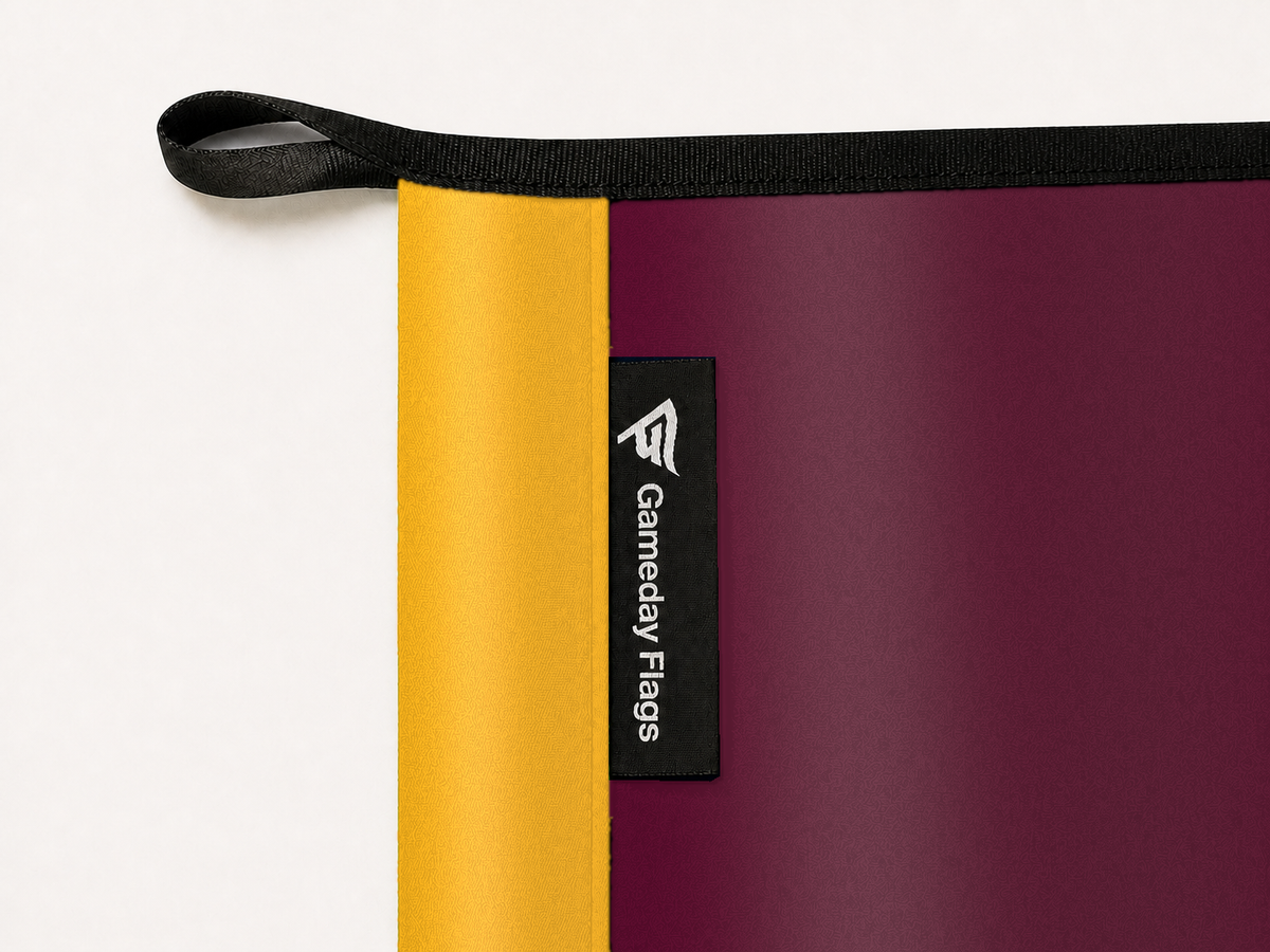 Minnesota Golden Gophers Authentic Gameday Flag construction detail — restrained woven-satin Minnesota Golden Gophers Accent sewn header, textured Minnesota Golden Gophers Primary face, crisp woven Gameday Flags tag and controlled contact shadow, black loop, perimeter webbing, and stitching — source_sha256=cfa2217c56704d07ff601b625cf8c35cb7acddd2ccdafca449368b418ed237c9