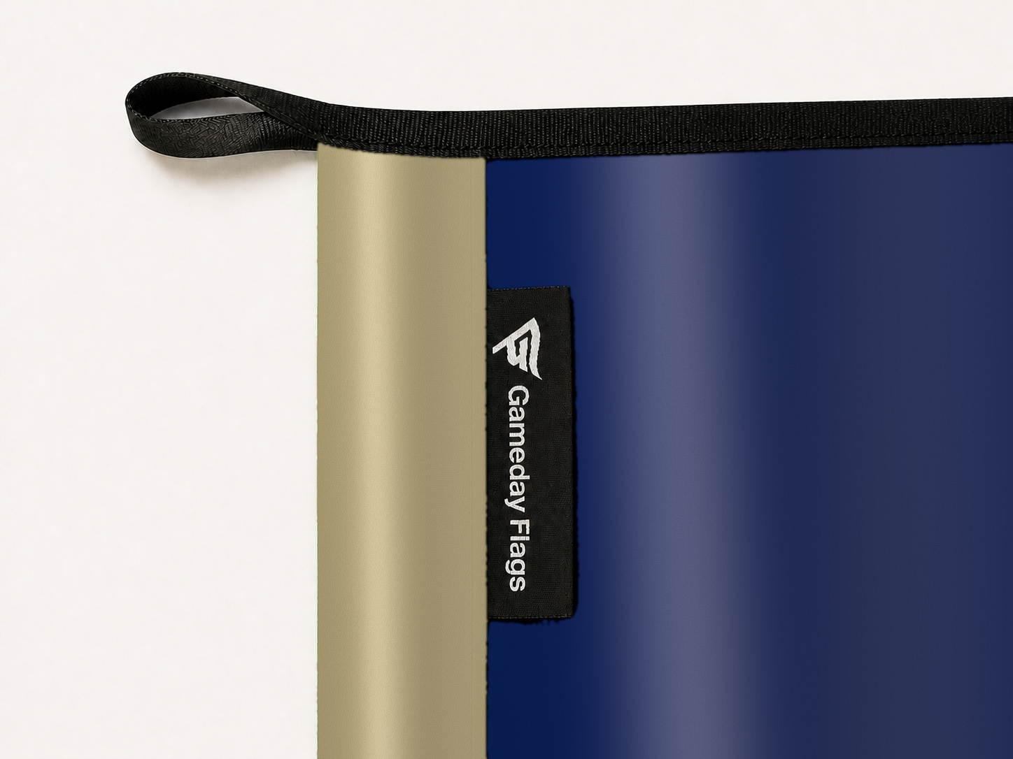 Navy Midshipmen Authentic Gameday Flag construction detail — restrained woven-satin Navy Midshipmen Accent sewn header, textured Navy Midshipmen Primary face, woven Gameday Flags tag, black loop, perimeter webbing, and stitching — source_sha256=91eefbb8628cb30d01b7ec2bcc55a4dfbfad5247c3d21544f0a932d6fc941f9e