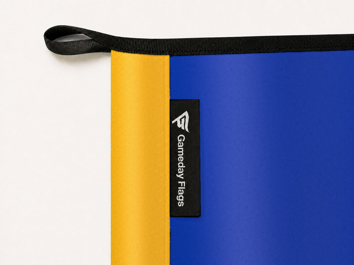 San José State Spartans Authentic Gameday Flag construction detail — restrained woven-satin San José State Spartans Accent sewn header, textured San José State Spartans Primary face, crisp woven Gameday Flags tag and controlled contact shadow, black loop, perimeter webbing, and stitching — source_sha256=b1f19722105f15c89dbe28347b360775fc11610ec1826750ad3feddc136e8938