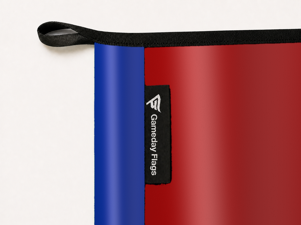 SMU Mustangs Authentic Gameday Flag construction detail — restrained woven-satin SMU Mustangs Accent sewn header, textured SMU Mustangs Primary face, woven Gameday Flags tag, black loop, perimeter webbing, and stitching — source_sha256=3f7354c62044d503539c20e8b896a02e9ed78ea204788b0df1475d3aff6585e9