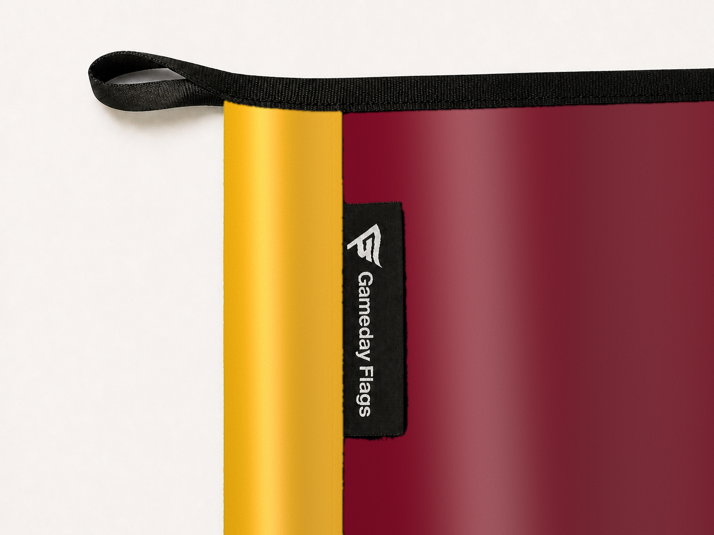UL Monroe Warhawks Authentic Gameday Flag construction detail — restrained woven-satin UL Monroe Warhawks Accent sewn header, textured UL Monroe Warhawks Primary face, woven Gameday Flags tag, black loop, perimeter webbing, and stitching — source_sha256=a161a210e0d51fa980da47891d45078861d0090c949208a731375e5f9046cc5c