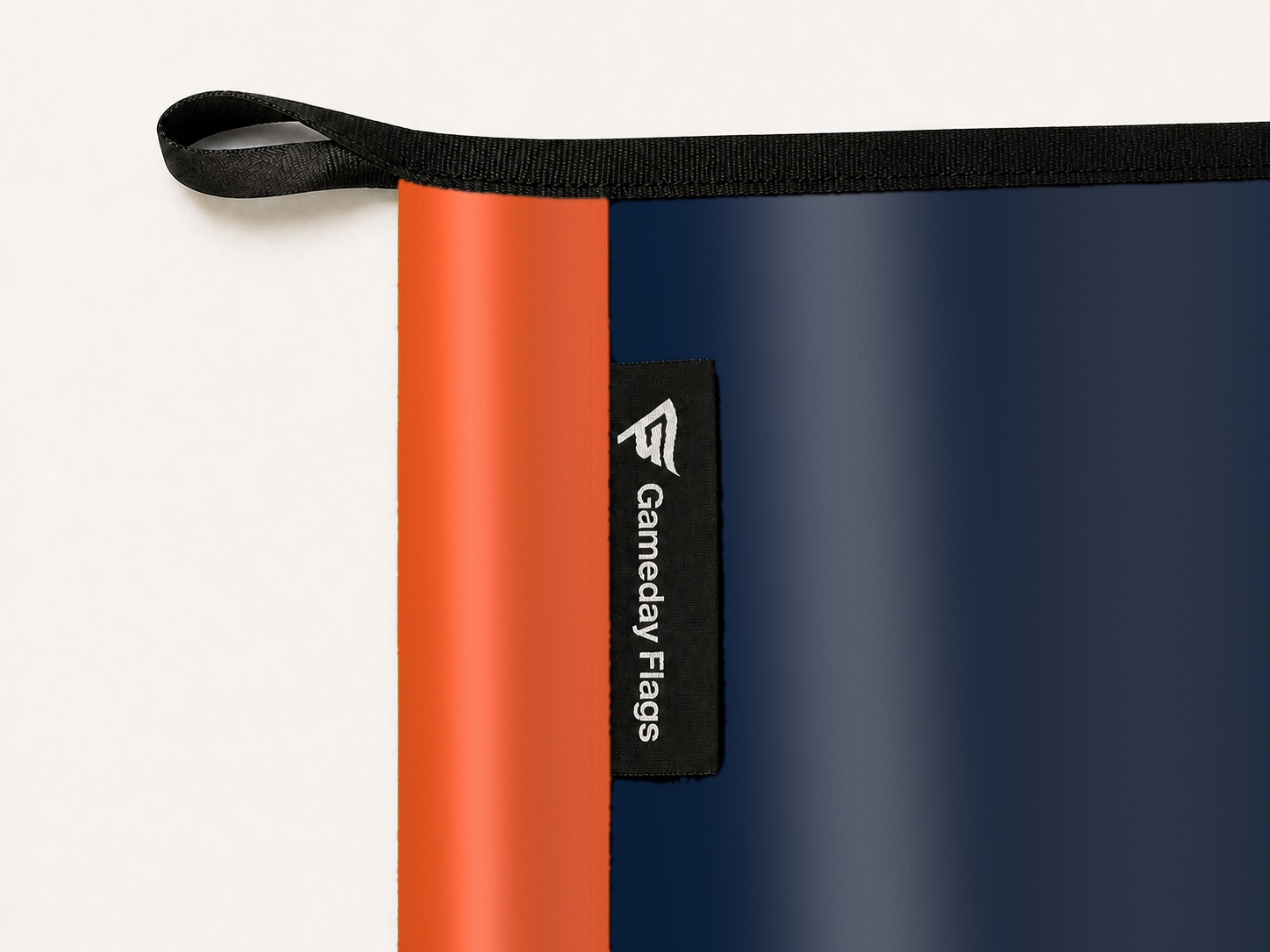 UTSA Roadrunners Authentic Gameday Flag construction detail — restrained woven-satin UTSA Roadrunners Accent sewn header, textured UTSA Roadrunners Primary face, woven Gameday Flags tag, black loop, perimeter webbing, and stitching — source_sha256=91c1b617049543cdffc260cb5d15fe95207186426394e337bd54de4e7c259d15