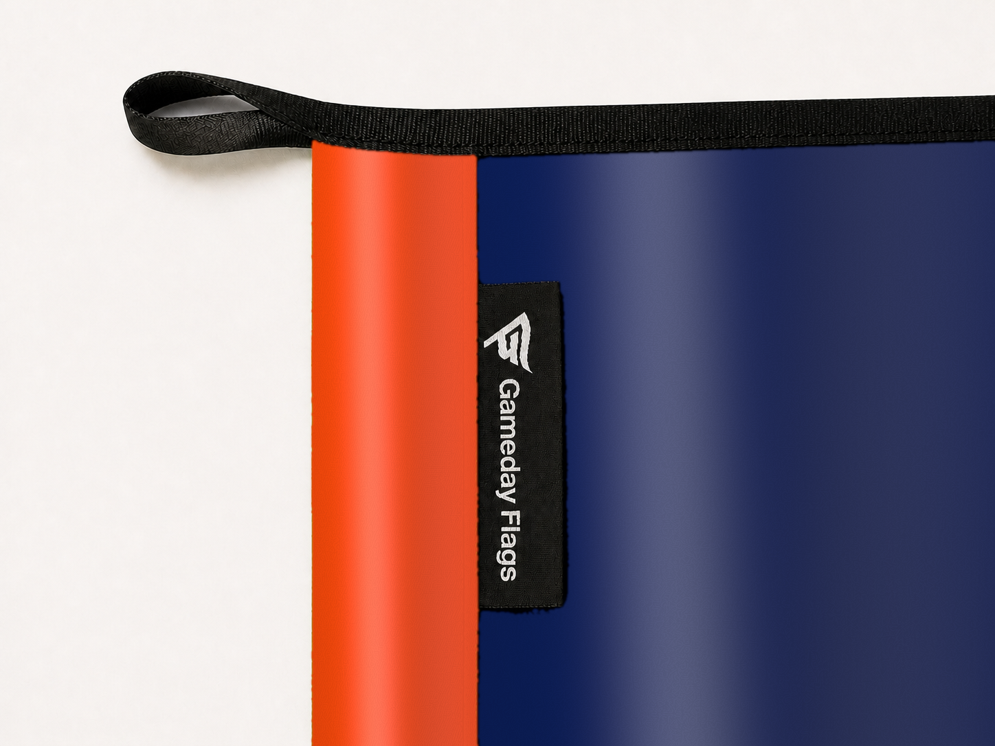 Edmonton Oilers Authentic Gameday Flag construction detail — restrained woven-satin Edmonton Oilers Accent sewn header, textured Edmonton Oilers Primary face, woven Gameday Flags tag, black loop, perimeter webbing, and stitching — source_sha256=3d16c5c99b1a6b735efe310e3aa4fbce257d01d081bbcc39582945c53084c7ba
