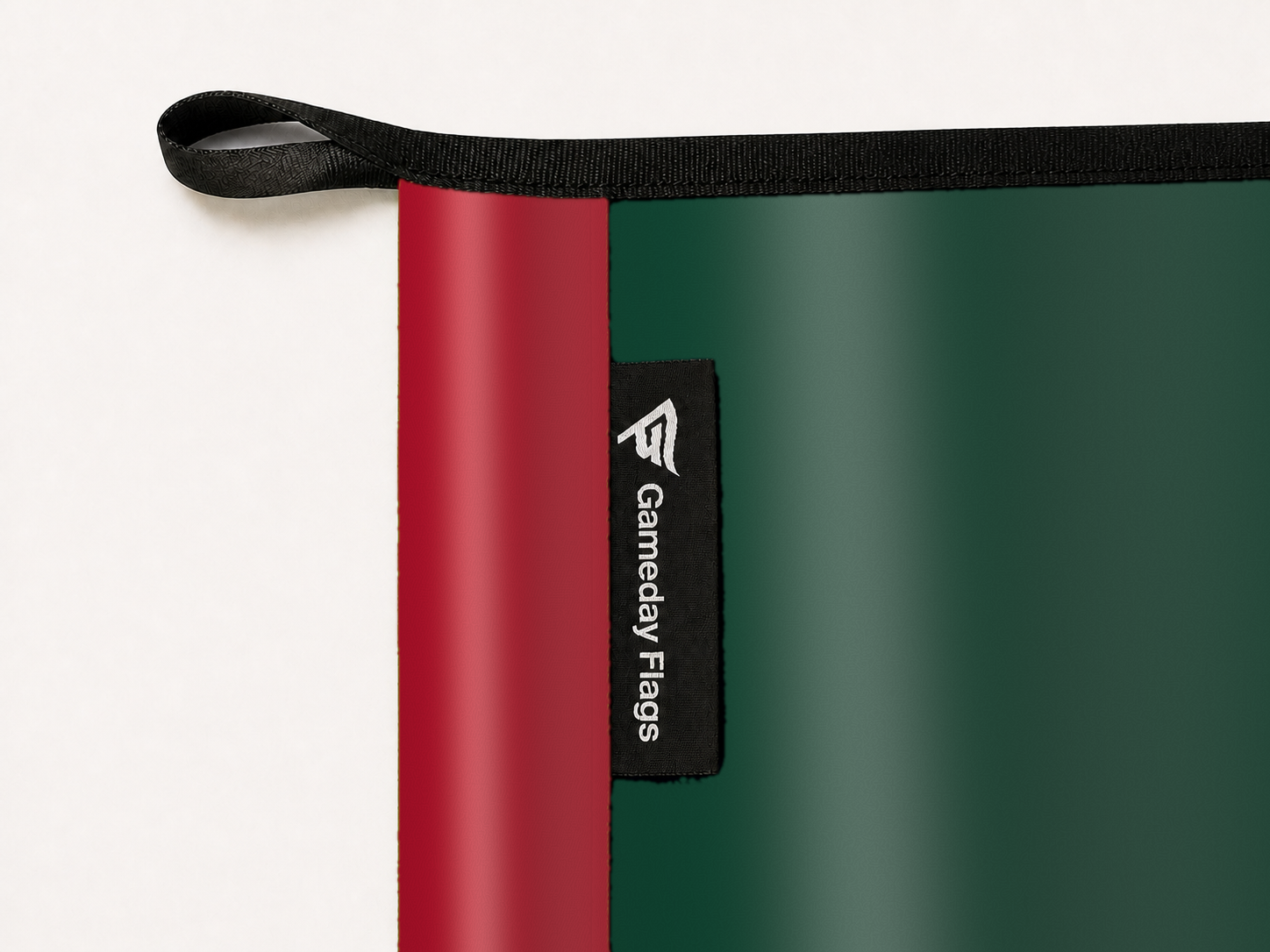 Minnesota Wild Authentic Gameday Flag construction detail — restrained woven-satin Minnesota Wild Accent sewn header, textured Minnesota Wild Primary face, woven Gameday Flags tag, black loop, perimeter webbing, and stitching — source_sha256=d8bf6101a8767282f72dfbbe341cf7dbd502168ca206cdb921d217108c1b440f