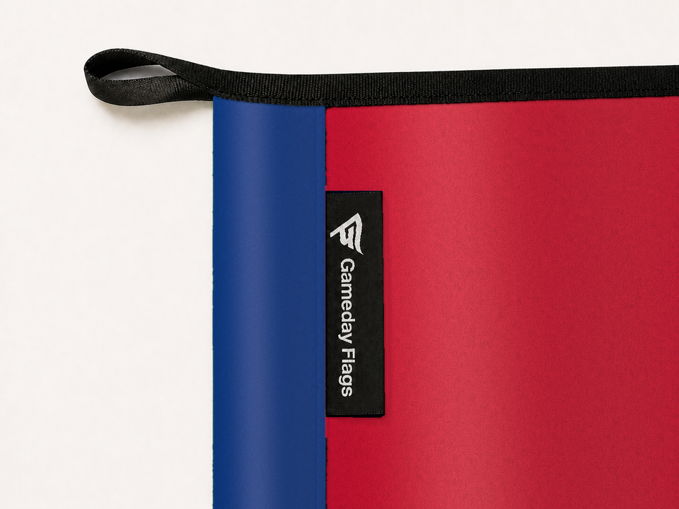 Montreal Canadiens Authentic Gameday Flag construction detail — restrained woven-satin Montreal Canadiens Accent sewn header, textured Montreal Canadiens Primary face, crisp woven Gameday Flags tag and controlled contact shadow, black loop, perimeter webbing, and stitching — source_sha256=76aea5d63659a3ca8baaae2d61cef3c90df1ae70209defffc785994d1bf8dc3d
