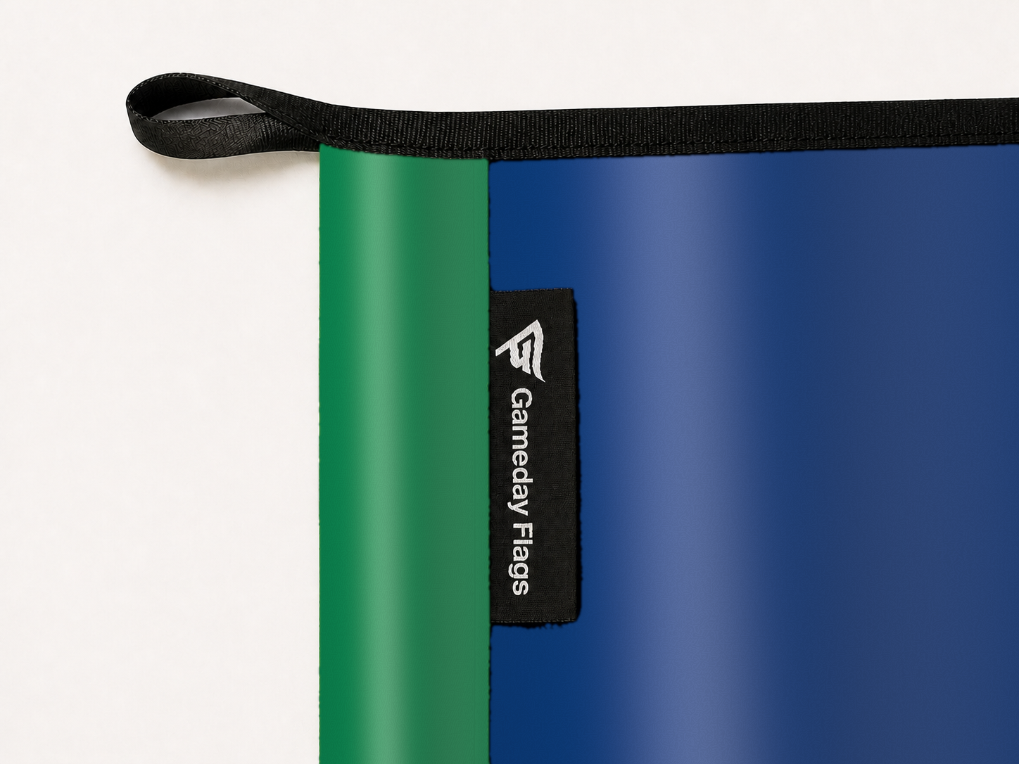 Vancouver Canucks Authentic Gameday Flag construction detail — restrained woven-satin Vancouver Canucks Accent sewn header, textured Vancouver Canucks Primary face, woven Gameday Flags tag, black loop, perimeter webbing, and stitching — source_sha256=aa1653865801575715637d842c1b6a1895b02941ebcc1b251d856b828cfa4e86