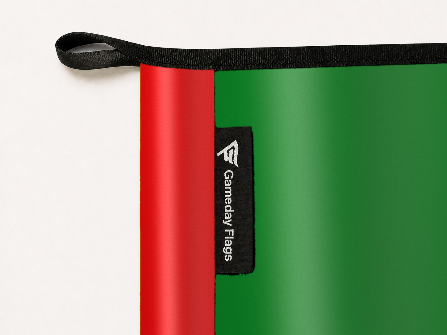 Classic Rainbow Flag Authentic Gameday Flag construction detail — restrained woven-satin Classic Rainbow Flag Accent sewn header, textured Classic Rainbow Flag Primary face, woven Gameday Flags tag, black loop, perimeter webbing, and stitching — source_sha256=7d2cfe402a7064508e1c01251e8f2584399869f474d94b9bc4a992576c18d6d5