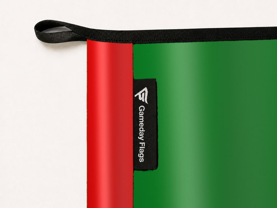 Classic Rainbow Flag Authentic Gameday Flag construction detail — restrained woven-satin Classic Rainbow Flag Accent sewn header, textured Classic Rainbow Flag Primary face, woven Gameday Flags tag, black loop, perimeter webbing, and stitching — source_sha256=7d2cfe402a7064508e1c01251e8f2584399869f474d94b9bc4a992576c18d6d5